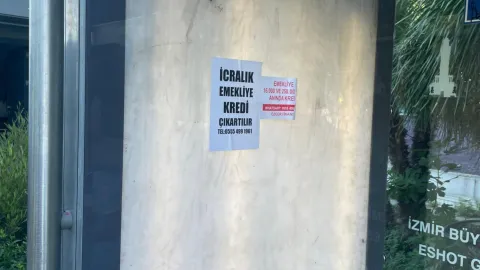 İzmir'de otobüs durağına yapıştırılmış icralık emekliye kredi ilanı