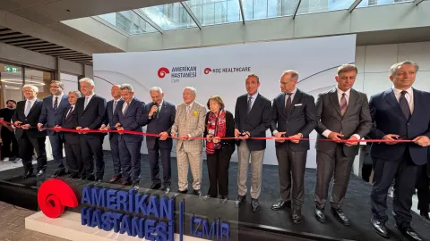 İzmir Büyükşehir Belediyesi meclis oturumu sırasında konuşmacı kürsüsünde duran bir kişi.