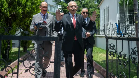 CHP Genel Merkezi önünde siyasi parti bayrakları ve kalabalık bir grup insan.