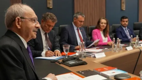 CHP Genel Merkezi önünde çekilmiş, parti bayraklarının göründüğü bir görsel.