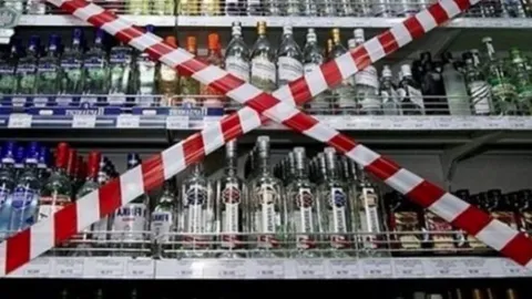 İş yerinde alkol şişelerinin bulunduğu bir rafın bulanık görüntüsü