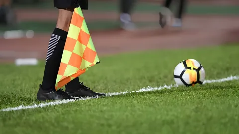 Futbol sahasında top ve hakem düdüğü görseli.
