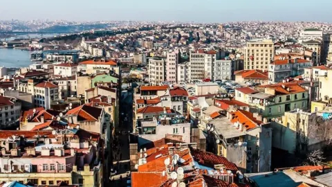 Türkiye'de bir apartman dairesi ve üzerinde Türkiye ve Rusya bayrakları ile para sembolleri.