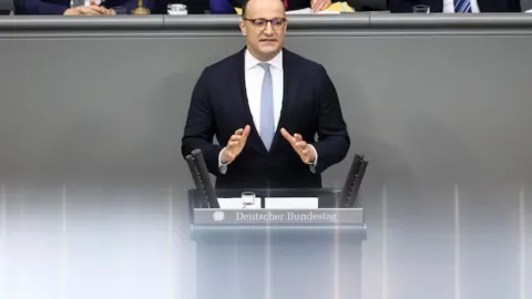 Alman siyasetçi Jens Spahn'ın taşıyıcı annelik yasaklarını savunup ABD'de çocuk sahibi olması sonrası istifa etmesiyle ilgili haber görseli.