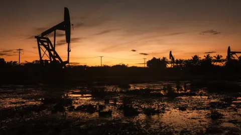 Venezuela petrol varilleri ve ABD bayrağı görseli.