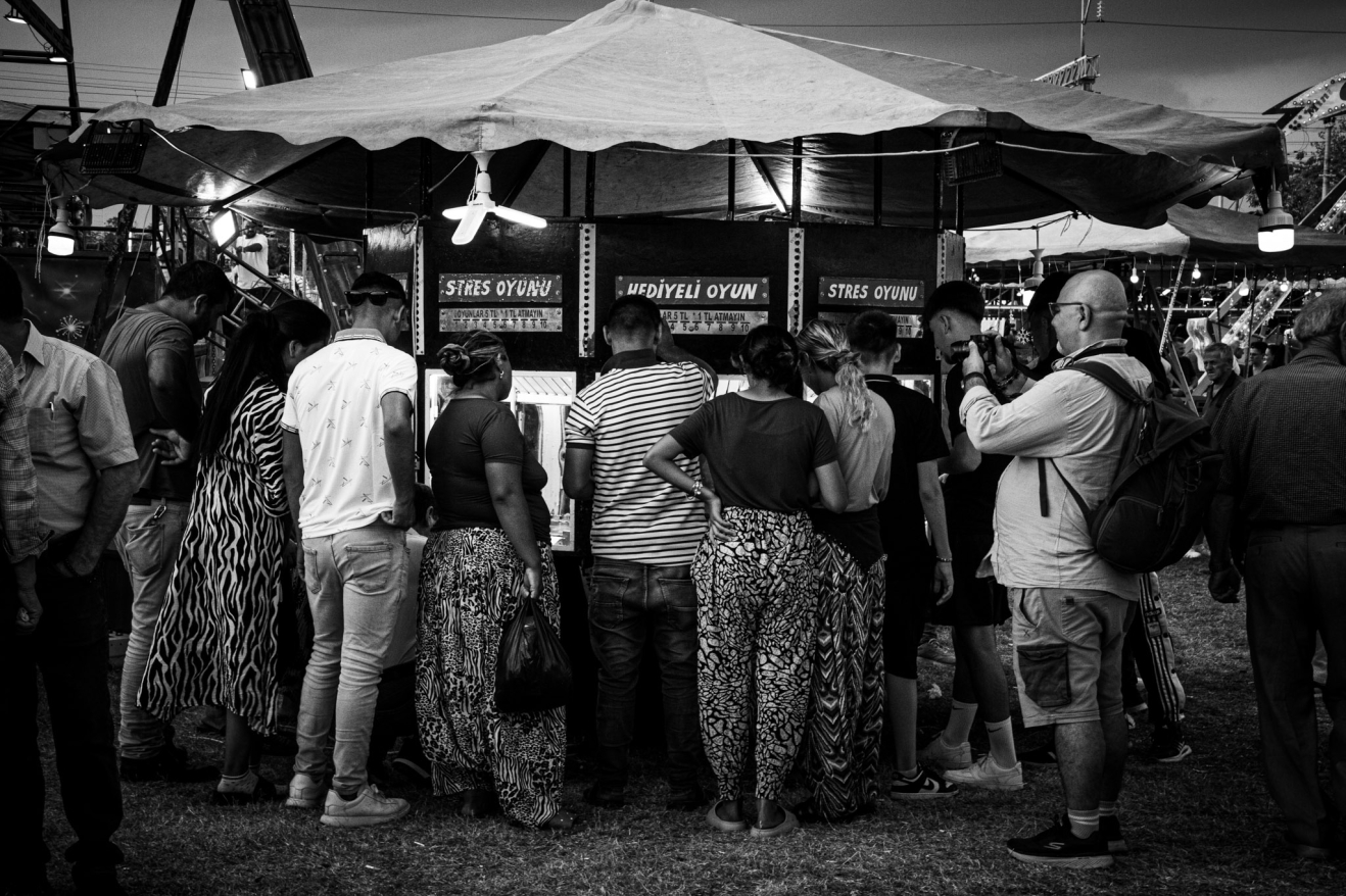 Lunapark alanı gittikçe canlanıyor. Cümbüşçülerin zurnalarını bastırıyor oyuncakların hoparlörlerinden yayılan pop müzik sesleri. Burada ayrı bir hayat akıyor, eğlenenler var eğlendirenler var. Gülenler var yorulanlar var. Ama hayat akıyor. Bir kısmı topun arkasında bir kısmı stres makinasının başında.