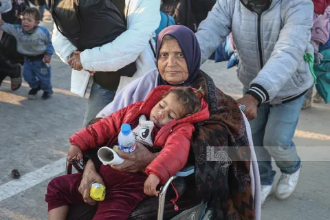 Dönüş yolunda tekerlekli sandalyede bir kadın ve kucağındaki çocuk