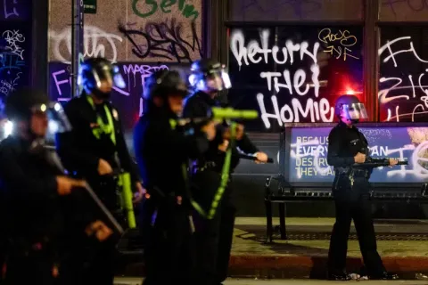 Belediye binasının yanına konuşlandırılmış Los Angeles polis memurlarının arkasında 'Adamları Geri Verin' yazan bir grafiti yer alıyor.